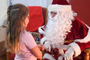 Christmas Lights Switch On & Late Night Shopping. A girl talking to Santa.