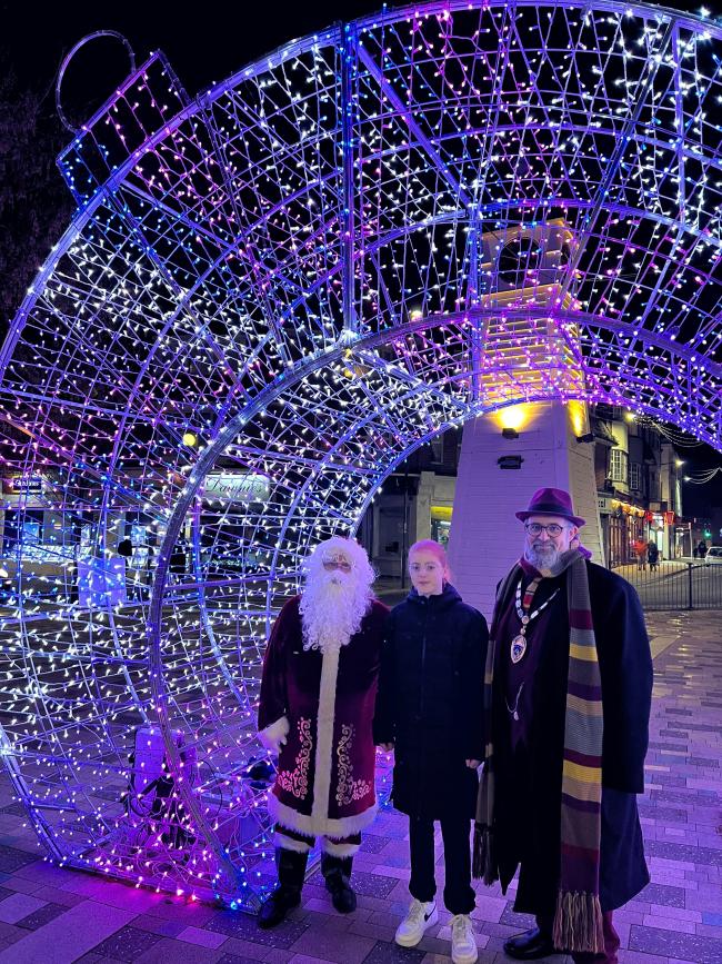 child with Town Mayor and Santa by a christmas lit up decoration