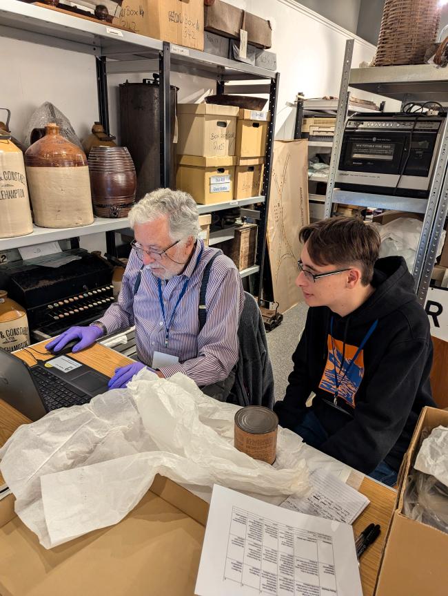 image of museum volunteer and staff member documenting some of the Museum's social history collections