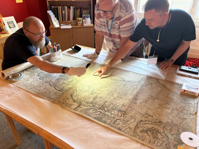 Museum volunteers examining the 45,000th object to be documented on the Museum's database, a map of Sussex from 1778