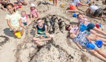 children laying in the sand