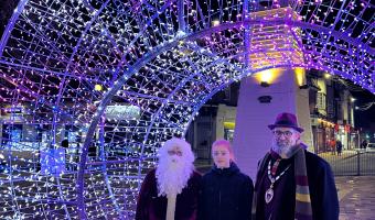child with Town Mayor and Santa by a christmas lit up decoration