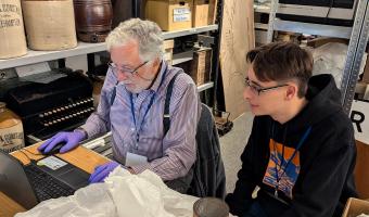 image of museum volunteer and staff member documenting some of the Museum's social history collections