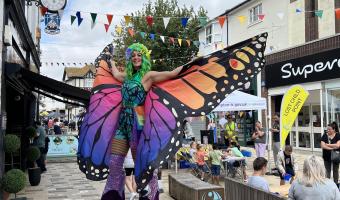 Human butterfly stilt walker from Summer High Street event 2025