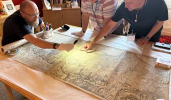 Museum volunteers examining the 45,000th object to be documented on the Museum's database, a map of Sussex from 1778
