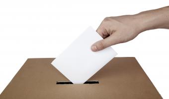 Ballot box with hand placing in vote